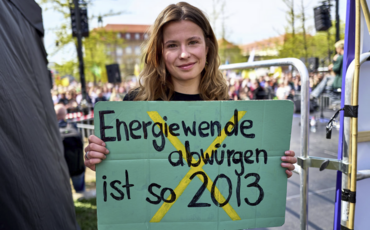Bild der Klimaaktivistin Luisa Neubauer bei der Demonstration in Berlin mit dem Plakat in der Hand mit der Aufschrift "Energiewende abwürgen ist so wie 2013"